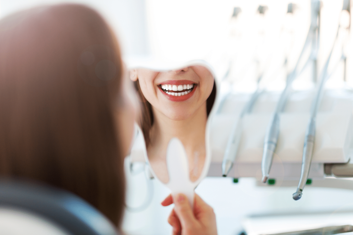 Woman smiling into a tooth shaped mirror