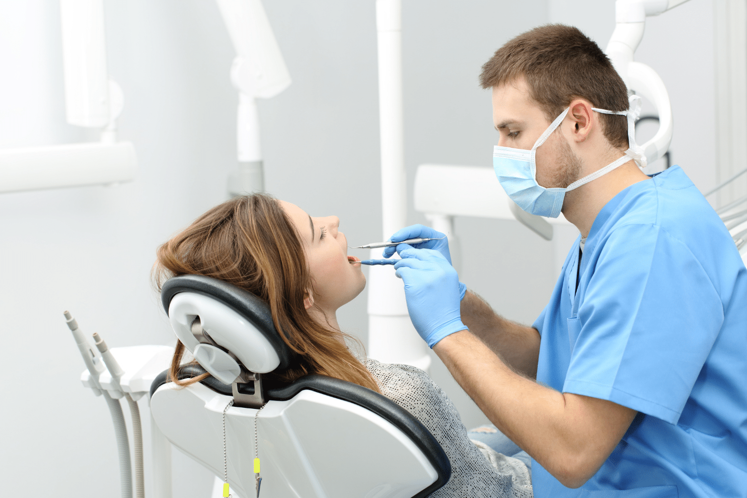 Dentist using dental tools to inspect teeth before tooth extraction - Cary, NC