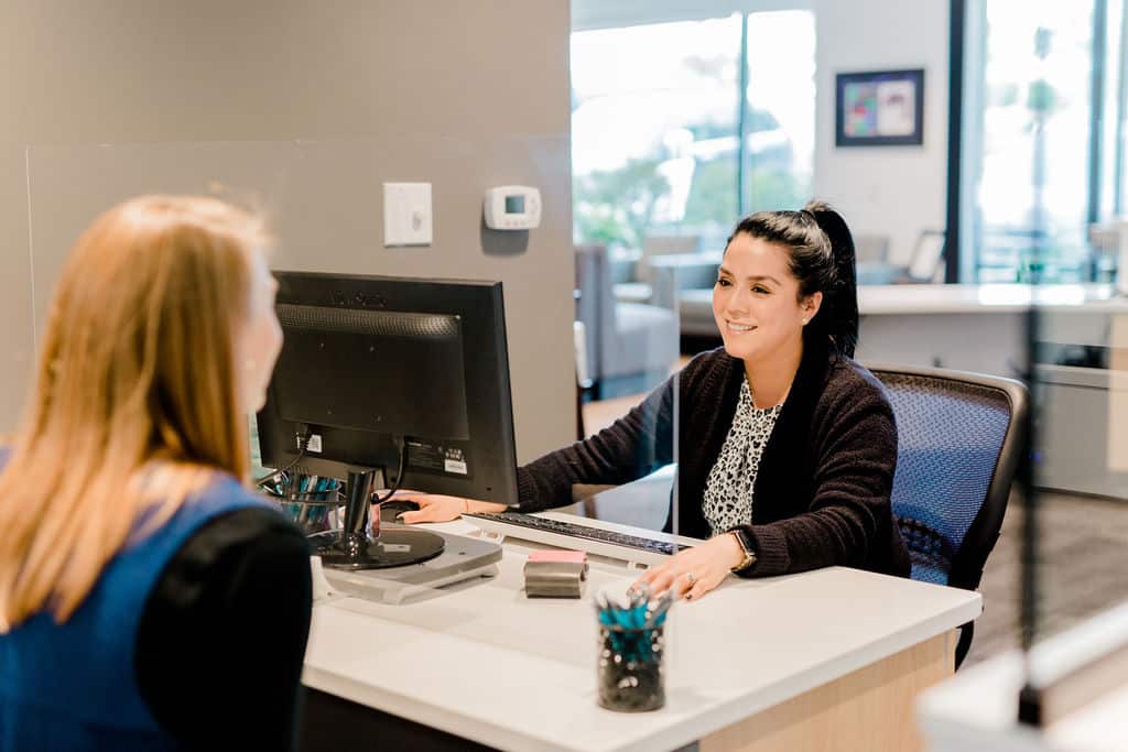 A dental patient at reception discussing dental treatment options