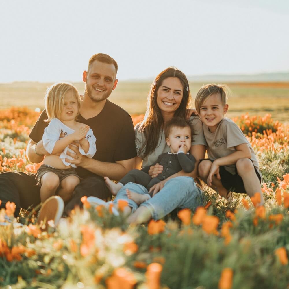 Family smiling in field of flowers