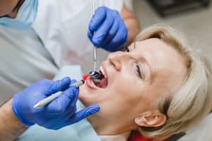 dentist checking a woman's tooth damage, dental restorations