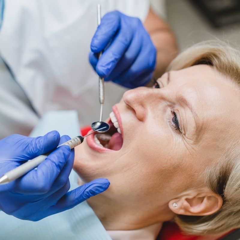 dentist checking a woman's tooth damage, dental restorations