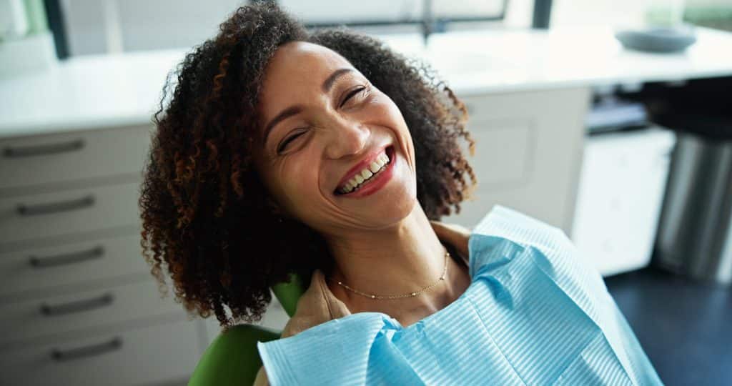smiling woman sitting in a dental chair. routine checkup