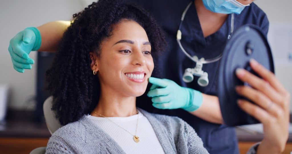 young woman smiling in a dental chair, routine dental checkup