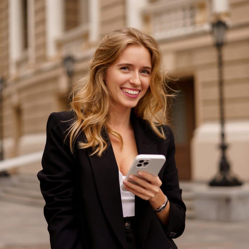 young woman confidently smiling on a city street