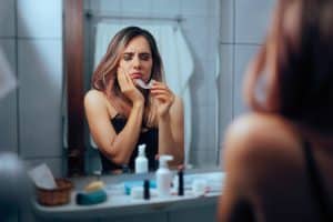 Woman suffers from sensitive teeth, bruxism pain